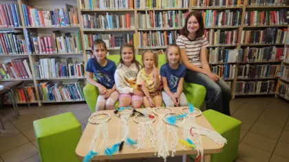 Dzieci siedzą na kanapie z łapaczami snów z makramy.