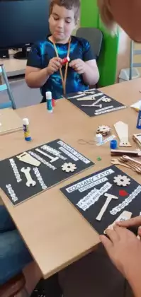 Uczniowie wykonują prezent dla taty