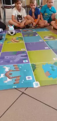 Dzieci kodują roboty na planszach.