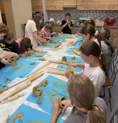 Warsztaty ceramiczne. Dzieci z gliny wykonują kubki.