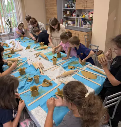 Warsztaty ceramiczne. Dzieci z gliny wykonują kubki.