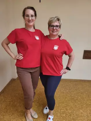 Panie prezentują uszyte koszulki patriotyczne.