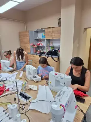 Uczestniczki spotkania szyja koszulki białe lub czerwone.