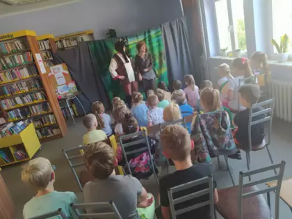 Aktorzy teatralni przestawiają spektakl w bibliotece.