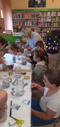 Na zakończenie zajęć plastycznych uczestnicy tworzą morze w słoiku.