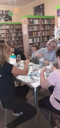 Na zajęciach w bibliotece uczestnicy wykonują morze w słoiku.