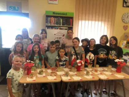 Dzieci pozują do wspólnego zdjęcia ze swoimi kubkami.