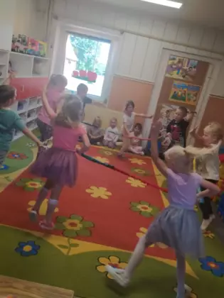 Przedszkolaki bawią się na dywanie w przedszkolu.