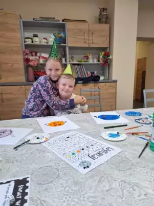 Dzieci rysują farbami kropkę na kartce.