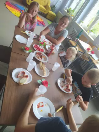 Dzieci zjadają poczęstunek przygotowany przez Panią bibliotekarkę.