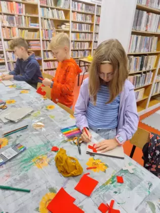Dzieci wycinają i malują kredkami obrazki.
