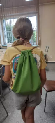 Uczestniczka pokazuje na plecach swój uszyty workoplecak.