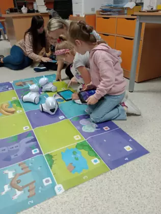 Dzieci w bibliotece na tabletach programują przejście dla robotów.