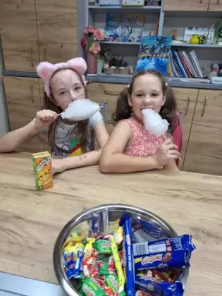 Dziewczynki jedzą watę cukrową.