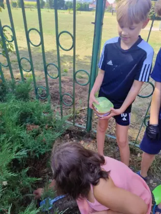 Dzieci znajdują skarb pod krzakiem.