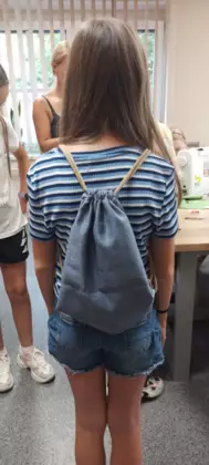 Uczestniczka pokazuje na plecach swój uszyty workoplecak.