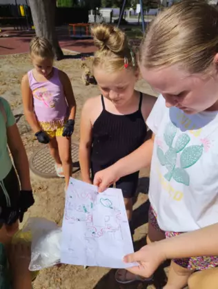 Uczestnicy według mapy, szukają skarbu na placu zabaw.