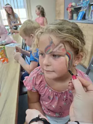 Dziewczynka ma na twarzy pomalowanego motyla.