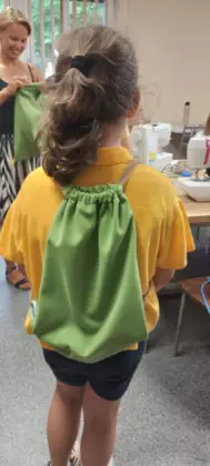 Uczestniczka pokazuje na plecach swój uszyty workoplecak.