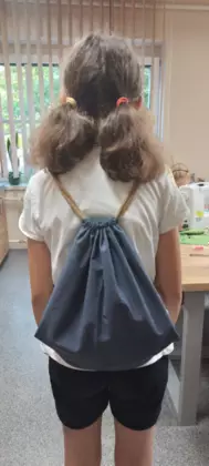 Uczestniczka pokazuje na plecach swój uszyty workoplecak.