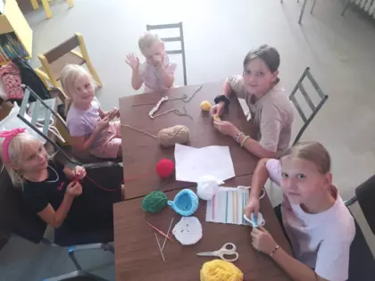 Uczestniczki zajęć szydełkują maskotki.