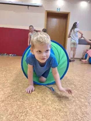 Chłopczyk przechodzi przez tunel na kolanach.