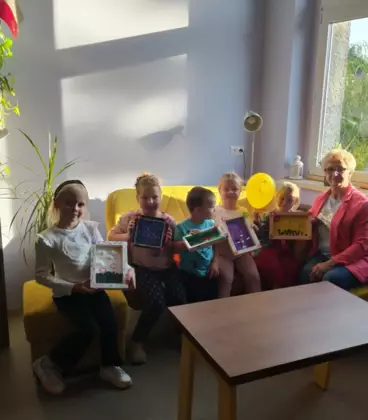 Dzieci wraz z panią bibliotekarką pozują do zdjęcia.