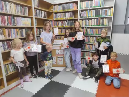 Dzieci wraz z pamiątkowymi dyplomami pozują do zdjęcia wspólnego po zajęciach.