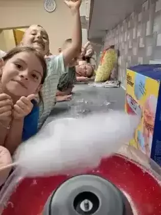 Dzieci stoją w kolejce po watę cukrową.