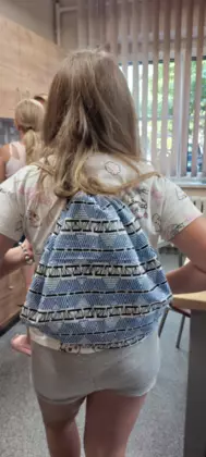 Uczestniczka pokazuje na plecach swój uszyty workoplecak.