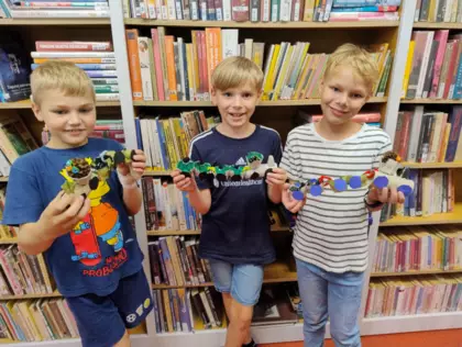 Trzech chłopaków pokazuje zrobiony pociąg.