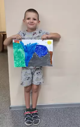 Szymon pokazuje swoją wersję kolejki górskiej na obrazie.