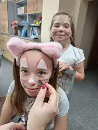 Dwie dziewczynki z pomalowanymi buziami w kotki.