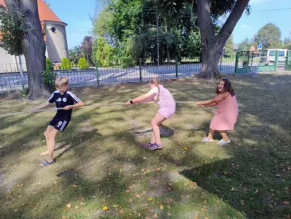 Przeciaganie liny na podwórku przed biblioteką.
