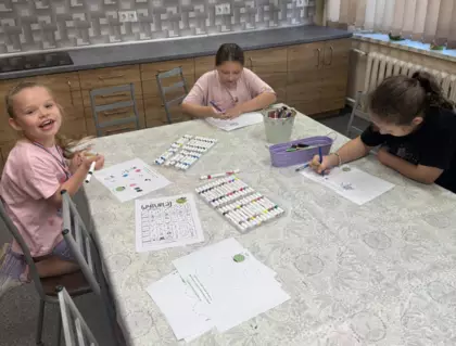 Dziewczynki bawią się w zabawę malując kolorową kropkę.