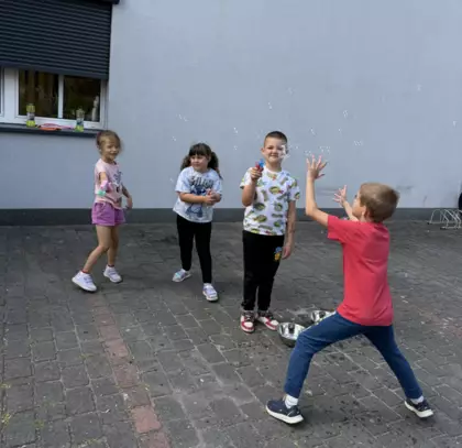 Dzieci puszczają bańki mydlane.