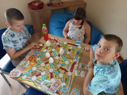 Trójka dzieci gra w grę planszową.