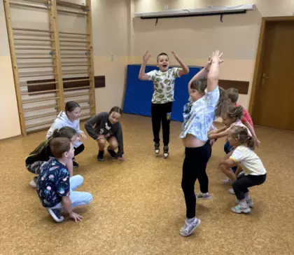 Dzieci bawia się w zabawy ruchowe na sali zabaw.