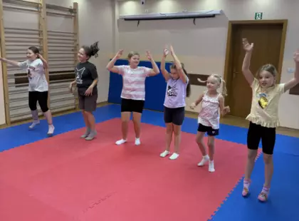 Dziewczynki wykonują gimnastykę na sali zabaw.