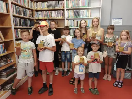 Wspólne zdjęcie uczestników zajęć. Dzieci trzymają swoje prace w rękach.