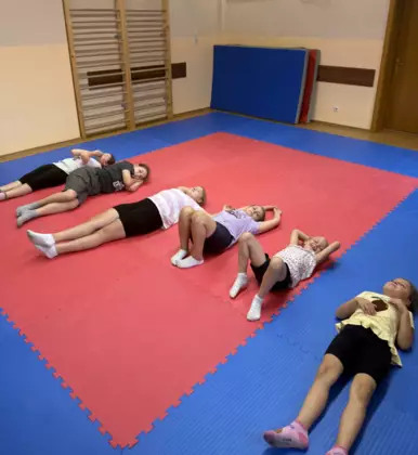 Dziewczynki wykonują gimnastykę na sali zabaw.