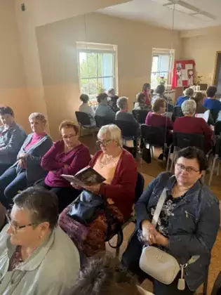 Uczestniczka spotkania czyta utwory Jana Kochanowskiego. W tle pozostali uczestnicy spotkania.