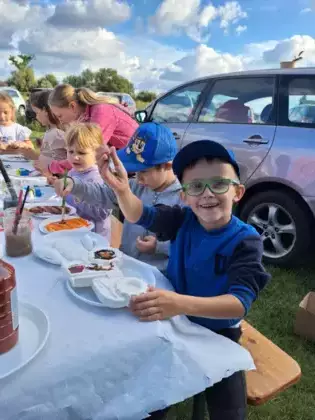 Chłopczyk maluje farbami figurkę traktora odlaną z gipsu.