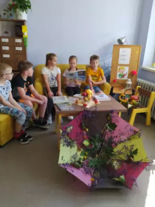 Uczniowie słuchają czytanej książki.