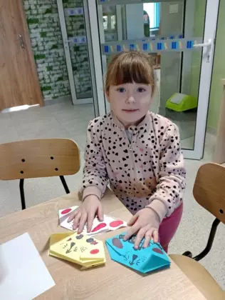 Dziewczynka pokazuje swoje zakładki w kształcie głowy psa.