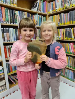 Dziewczynki trzymają w ręce wielkiego żołędzia.