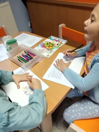 Uczestniczki  zajęć kolor ują piramidę żywienia.