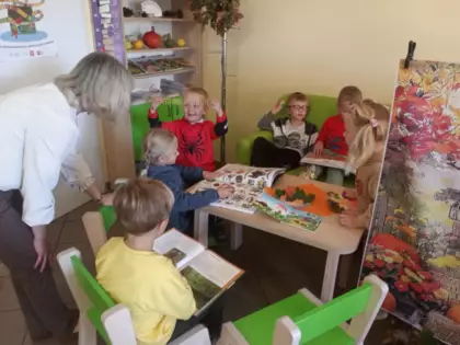 Przedszkolaki oglądają książeczki w bibliotece.