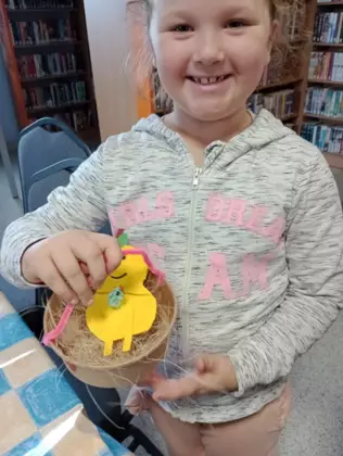 Dziewczynka prezentuje swoj witaminowy koszyczek, który zrobiła podczas zajęć.