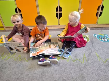 Przedszkolaki przeglądają książeczki.